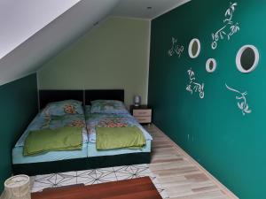 卢布涅维采Złota Rybka Lubniewice的一间卧室设有一张带绿色墙壁的床