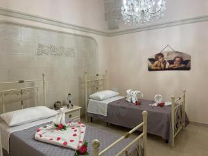 圣潘克拉齐奥萨伦蒂诺"Lu Barocco" a soli 10 min da Torre Lapillo的一间卧室配有两张床和吊灯。