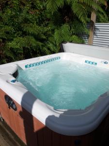 福克斯冰川Ivorytowers Accommodation的花园内的一个按摩浴缸