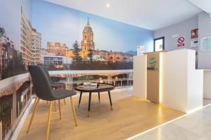 马拉加Málaga Rivas 34 Suites Homes的带阳台的客房配有桌子和椅子