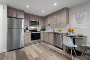 卡尔加里Contemporary 1br Home Full Kitchen Smarttv的厨房配有木制橱柜和不锈钢冰箱。