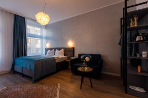 维也纳Florum Hotel的一间卧室配有一张床、一把椅子和一张沙发