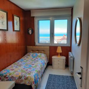莫格罗Adosado con vistas al mar los GIRASOLES的一间卧室设有一张床和一个窗口