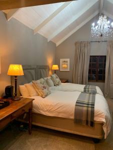 德尔斯特鲁姆Critchley Hackle Dullstroom Towers的一间卧室配有一张床、一张桌子和一个吊灯。