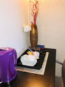 纽卡斯尔VnA Guesthouse的一张带紫色烤面包机和花瓶的桌子