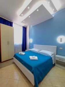 加利波利Al Mare的蓝色卧室,配有带毛巾的床