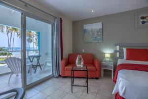 拉斯特拉纳斯考斯塔热纳海滩酒店的一间卧室配有一张床和一张沙发,并设有一个阳台
