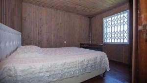 Ch'aisubaniЭко-дом в горах的木制客房的一张床位,设有窗户
