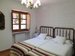 坎加斯德尔纳尔塞亚La Pumarada de Limés I的一间卧室设有两张床和窗户。
