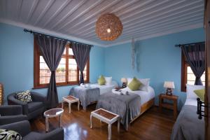 维纳德马Esencia Hotel Boutique的蓝色的客房配有两张床和一张沙发