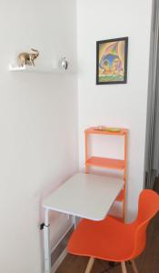 科恰班巴Estudio Monoambiente的客房内的白色桌子和橙色椅子
