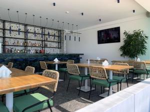 法里拉基Mazoren Art Hotel的用餐室配有木桌和绿色椅子