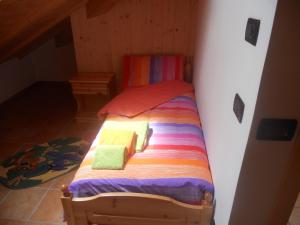 丰多Agritur Melango的一张带彩色床单和毛巾的小床