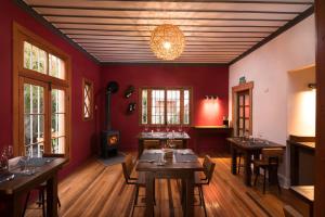 维纳德马Esencia Hotel Boutique的一间用餐室,配有红色的墙壁和木桌