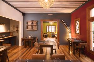 维纳德马Esencia Hotel Boutique的餐厅设有木桌、椅子和吊灯。