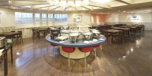 熊本熊本内斯特酒店的一间带桌椅的餐厅和一间大房间