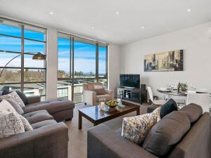 陶波24 Marina View Retreat - Taupo Holiday Apartment的一间带两张沙发的客厅和一间用餐室