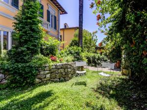 比萨Belvilla by OYO Villa Lazzarino的一个带两把椅子和石墙的庭院