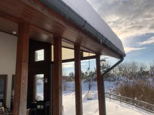 凯卡瓦自治市克切利度假屋酒店的一座带窗户的雪盖屋顶建筑