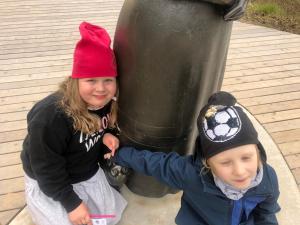 凯卡瓦自治市克切利度假屋酒店的两个年轻女孩站在垃圾桶旁边