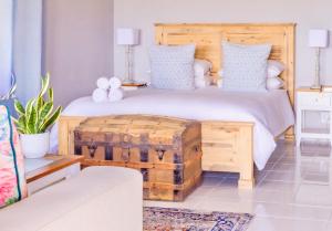 阿多河滨庄园酒店的一间卧室配有一张大床和木制床头板