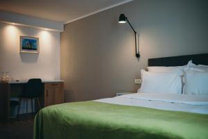 德罗贝塔-塞维林堡Nest Guesthouse的一间卧室配有一张床、一张桌子和一盏灯