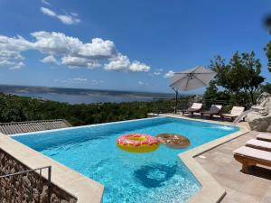 斯塔利格拉德-帕克利尼卡Lovely Holiday Home in Starigrad的一个带遮阳伞和2个充气式泳池
