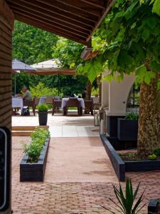 米米藏Hotel Au Bon Coin du Lac的户外庭院配有桌椅和树木。