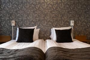 斯卡拉Skara Stay & Go的卧室内的两张床和黑色枕头