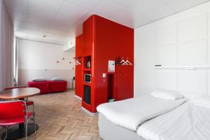 坦佩雷坦佩雷欧曼拉酒店的一间设有床和桌子的房间,以及红色的墙壁