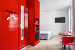 坦佩雷坦佩雷欧曼拉酒店的红色的房间,有红色的门和一间卧室