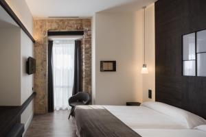 巴塞罗那Hotel Sant Agustí的配有一张床和一把椅子的酒店客房