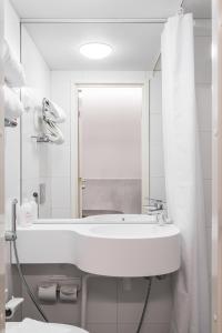 坦佩雷坦佩雷欧曼拉酒店的白色的浴室设有水槽和镜子