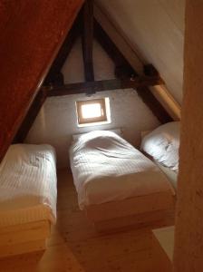 格兰德冯泰尼度顿农度假屋的阁楼卧室设有两张床和窗户。