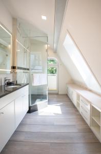 奥斯赛拜-屈隆斯博恩Villa Vivaldi的阁楼厨房配有白色橱柜和窗户。