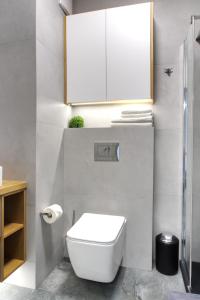 波兹南Essence Apartments Sapphire的一间带白色卫生间和橱柜的浴室