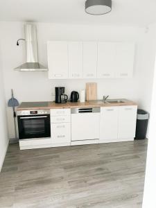 普福尔茨海姆PF Unterkunft的厨房配有白色橱柜和炉灶烤箱。