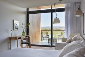 托罗埃利亚-德蒙特格里Empordà Golf Resort的一间卧室配有一张床,客厅享有美景。