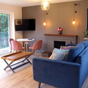 GlandoreCrow's Nest Glandore - 1 - Self Catering的客厅设有蓝色的沙发和壁炉