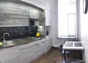 文尼察LUX Apartments的厨房配有水槽和带桌子的台面