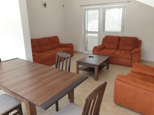 泽莱尼卡Apartmani Zlatko的客厅配有桌子、沙发和椅子