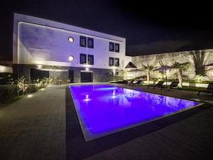 蓬塔德尔加达CFS Azores Guest House的一座游泳池,在晚上在建筑物前