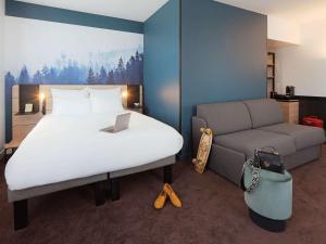 安纳马斯Novotel Annemasse Centre - Porte de Genève的酒店客房,配有床和沙发
