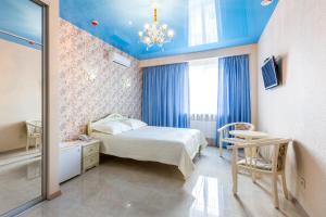 卡缅斯科耶普瑞米尔酒店的一间卧室设有一张床和蓝色的天花板
