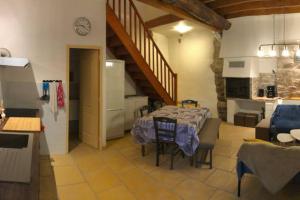 孔夫朗自由城Les Maisons du Conflent, maisons familiales en pierre au coeur des remparts的厨房以及带桌子的客厅。