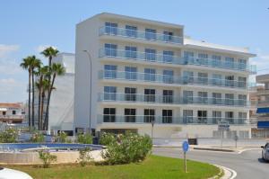 帕尔马海滩圣约蒂酒店的一座白色的建筑,前面有棕榈树