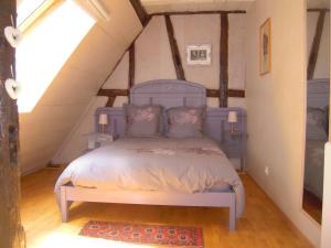 利克维Appartement Le Chez Soi Riquewihr的阁楼卧室配有蓝色床
