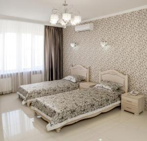 卡缅斯科耶普瑞米尔酒店的一间卧室配有两张床和吊灯。