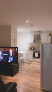 阿伯丁Heart Of Aberdeen City Centre 3 Bedrooms Apartment的带电视的客厅和厨房。