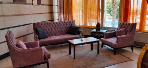 ‘Ezbet Sa‘dî MugâwirFayoum Hotel的一间设有两把椅子和一张桌子的等候室